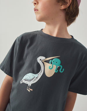 Stylized catalog shot of a child wearing the Eld Pelican Relaxed-Fit Jersey Graphic Tee for a cool playful look from the Summer collection of Filipino kids fashion brand Gingersnaps Philippines,.