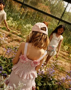 Campaign photo of the Josephine Striped Peplum Top with Flower Appliqué for kids from the Spring Summer collection of Filipino kids fashion brand Gingersnaps Philippines, featuring striped seersucker fabric and floral appliqué detail.
