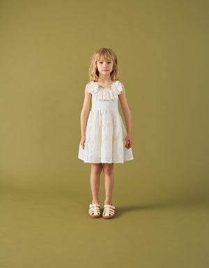 Campaign photo of the Addison Dress with Corsage & Tiered Skirt for kids from the Spring Summer collection of Filipino kids fashion brand Gingersnaps Philippines, featuring an off-white palette, corsage accent, and tiered floral skirt.