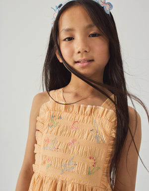 Close-up front detail of the Emily Ruffled Apron Dress with Botanical Embroidery, highlighting floral embroidery and ruffled apron details from the Spring Summer collection of Gingersnaps Philippines.
