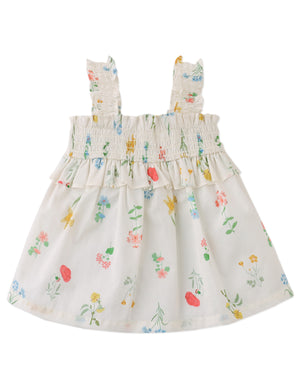 Campaign photo of the Baby Jennie Smocked Cotton Top for kids from the Spring Summer collection of Filipino kids fashion brand Gingersnaps Philippines, featuring airy white fabric with delicate floral prints and smocked details.