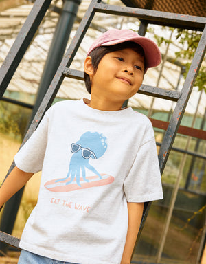 Campaign photo of the Oruo Surfing Octopus Relaxed-Fit Graphic Tee for kids from the Summer collection of Filipino kids fashion brand Gingersnaps Philippines, featuring a playful surfing octopus graphic and relaxed style.